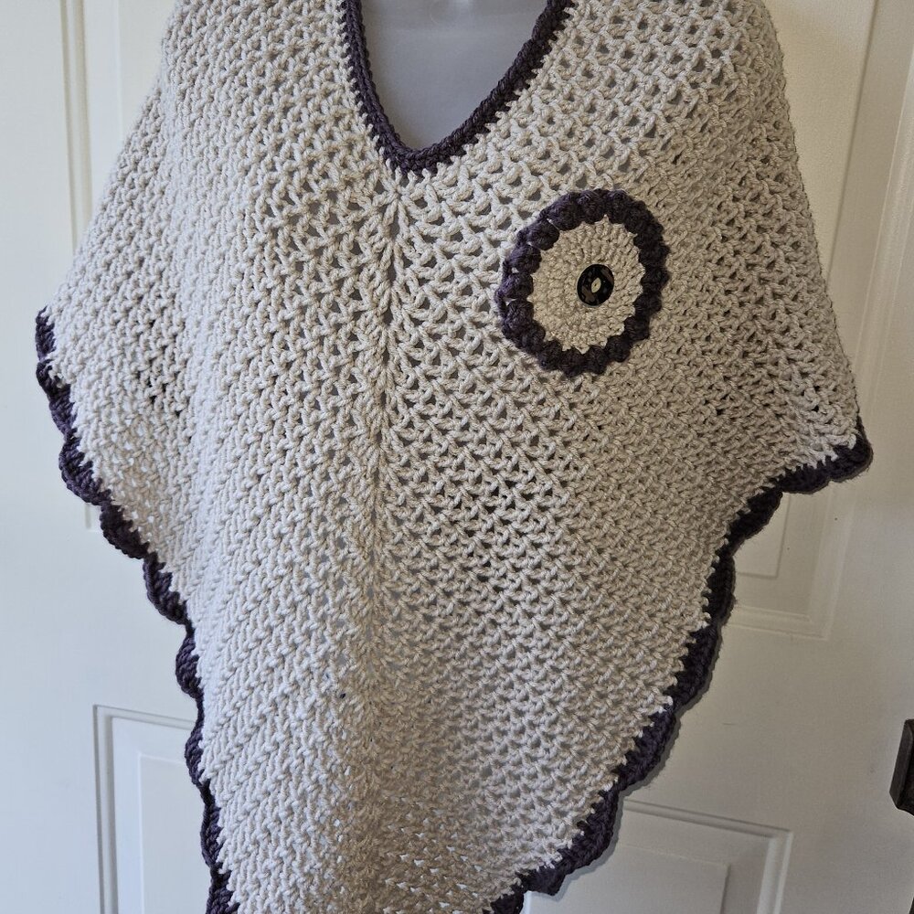PONCHO IN BEIGE AND BROWN TRIM WITH MATCHING DECORATIVE FLOWER